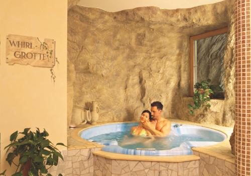 un hombre y una mujer sentados en un jacuzzi en un resort en Pension Felseneck, en San Leonardo in Passiria