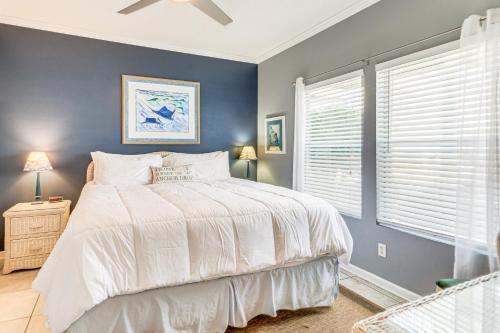 a bedroom with a white bed and a blue wall at Destin Ground-Level Condo w/ Private Beach Access in Destin