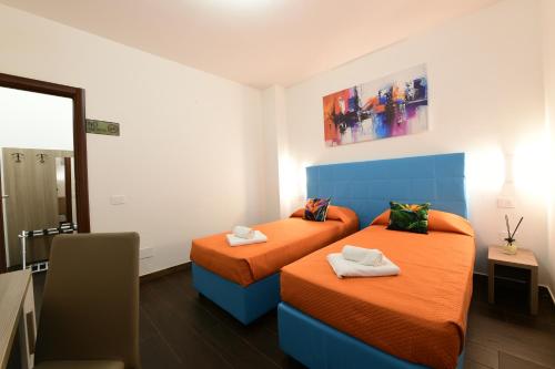a room with two beds with orange sheets at 100 Passi dal Porto in Civitavecchia