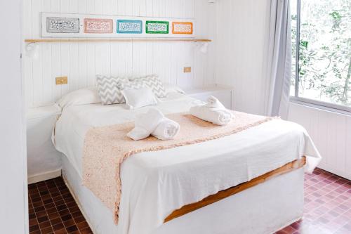 a bedroom with a white bed with towels on it at La Posada del Abra in Tigre