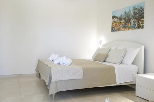 a white bedroom with a bed with towels on it at Masseria Pozzelle in Otranto