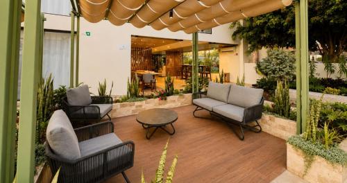 a patio with chairs and a table in a building at La Posada Hotel y Suites in San Luis Potosí