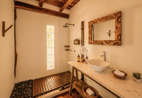a bathroom with a sink and a mirror on the wall at Olivia Oceanfront Tulum in Tulum