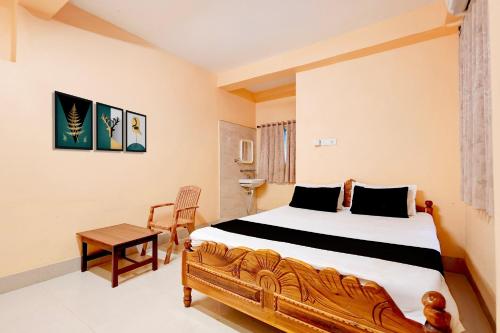 a bedroom with a large bed and a table at Hotel O Snow White in Bhadrak