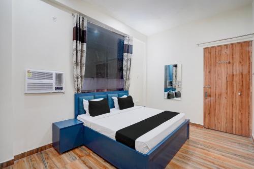 a bedroom with a blue and white bed and a window at Hotel O Sapphire Grand in Lucknow