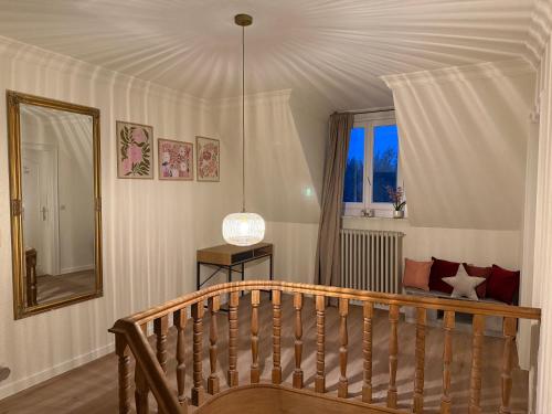 a room with a wooden staircase and a mirror at Maison Frieda in Oostkamp