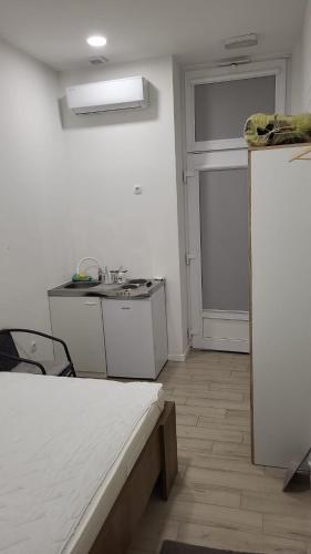 a white room with a bed and a sink at Studio apartman Mara in Imotski