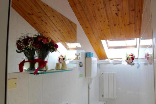 a kitchen with a refrigerator with flowers on a shelf at Depandance Blue Hotel in Cesenatico