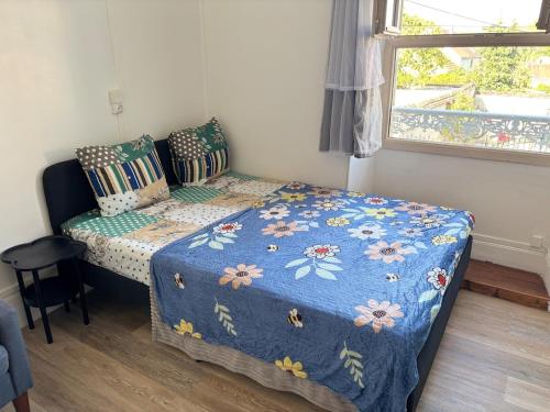 a small bedroom with a bed with a blue comforter at Logement Angèle in Malesherbes