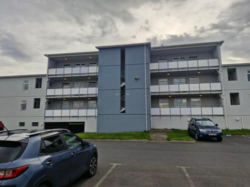 a building with a car parked in a parking lot at Top floor apartment with view in Reykjavík
