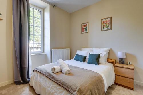 a bedroom with a large white bed with a window at La Maison des Prés - Maison bourgeoise de 1890 in Montceau-les-Mines