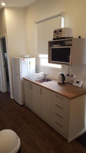 a kitchen with a counter with a microwave and a refrigerator at Lara Lodge in Lara