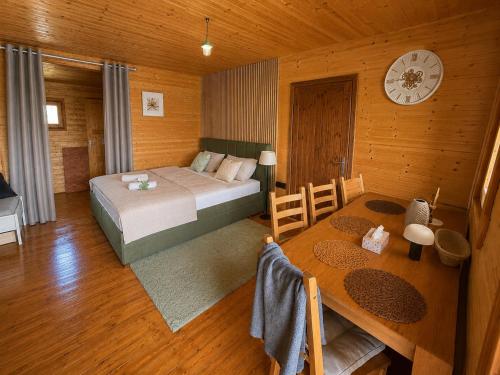 a bedroom with a bed and a table and a clock at Lake View Glamping pod Radyní bez tekoucí vody s omezenou elektřinou in Hvížďalka