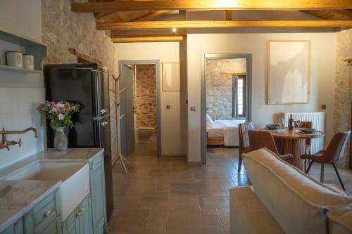 a kitchen with a refrigerator and a dining room at Penelope Suites With View Meteora in Kalabaka