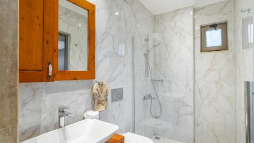 a bathroom with a shower and a sink and a mirror at Secluded Sea-View Family Escape Villa Bella 3 Lale in Üzümlü