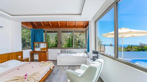 a bathroom with a tub and a bed and chairs at Secluded Sea-View Family Escape Villa Bella 3 Lale in Üzümlü