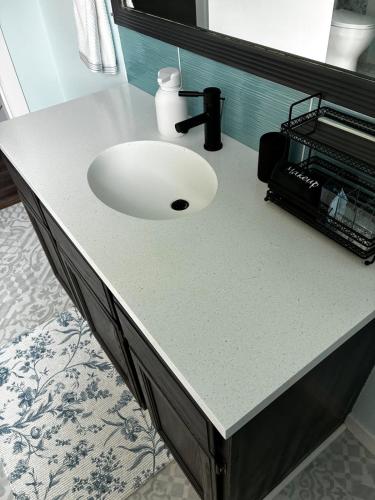 a white sink in a bathroom with a counter at The Private Perch in Nelson