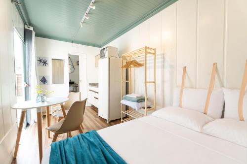a bedroom with a bed and a desk and a table at Marco Zero Containers - Próximo à Roda Gigante in Balneário Camboriú