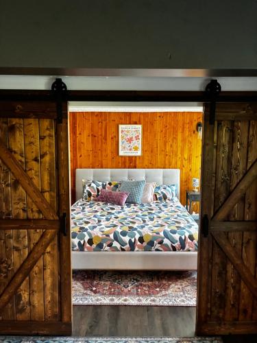 a bedroom with a bed with wooden walls and wooden doors at The Private Perch in Nelson