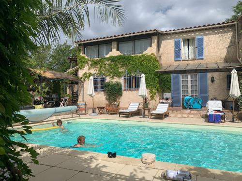 a couple of people in a swimming pool at Villa La Rose des Vents in Tourrettes