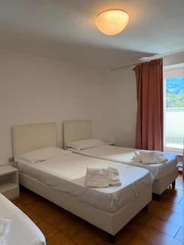 zwei Betten in einem Zimmer mit Fenster in der Unterkunft Hotel Riposo in San Pellegrino Terme