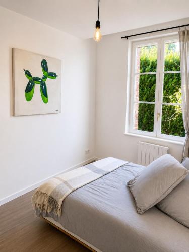 a bedroom with a bed and a window at Brick - Loft design avec parking privé in Saint-Désir