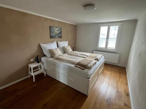 a bedroom with a white bed with a window at Schöne Wohnung in Feldkirch in Feldkirch