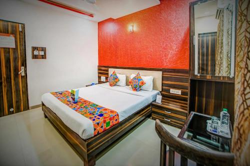 a bedroom with a bed with a red wall at Crown Hotel Aadoree - Near Mumbai Airport, BKC Visa Consultant , Jio Convention Centre in Mumbai