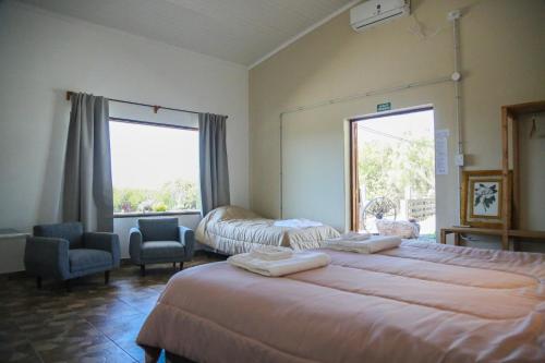 a hotel room with two beds and a window at Buenas Vibras Hostería Rural in Chicoana