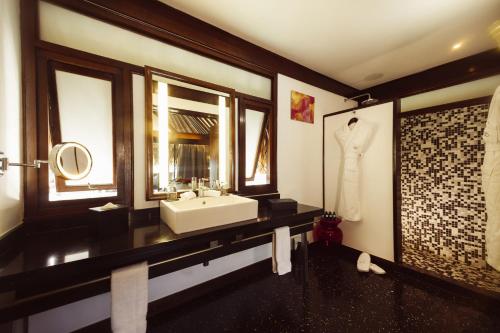 a bathroom with a sink and a mirror at Sofitel Kia Ora Moorea Beach Resort in Maharepa