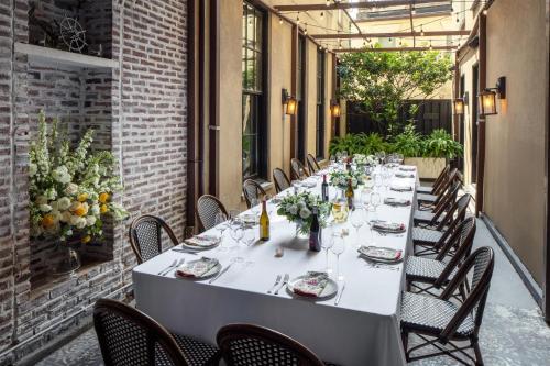a long table on a patio with chairs and flowers at The William Fell Baltimore, Tapestry Collection by Hilton in Baltimore