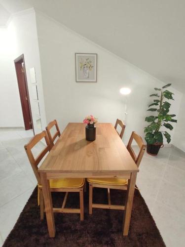 a wooden dining room table with chairs and a plant at Mivô - Alcochete Views & Comfort in Alcochete