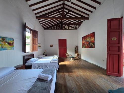 a large room with two beds and a wooden floor at Republicano Hostal in Jericó