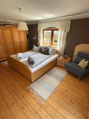 a bedroom with a large bed and a chair at FEWO Schulze Jonsdorf, Waldblick in Kurort Jonsdorf