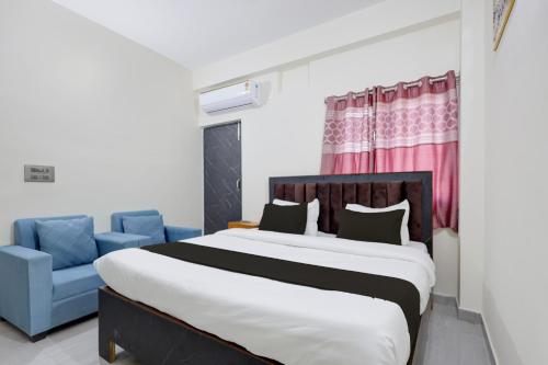 a bedroom with a large bed and a blue chair at Hotel O VIP Inn in Bankipur