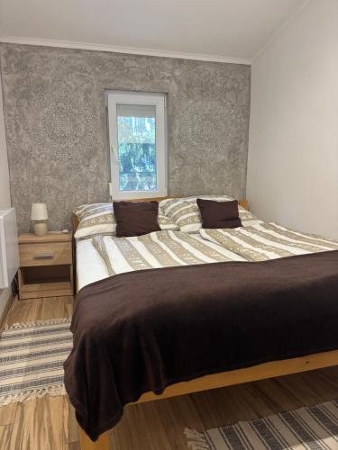 a bedroom with a large bed and a window at Arborétum in Harkány