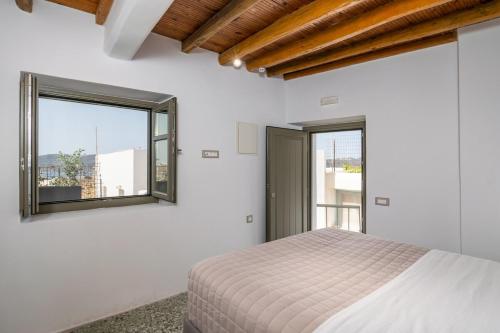 a white bedroom with a bed and a window at Astraea in Tripiti