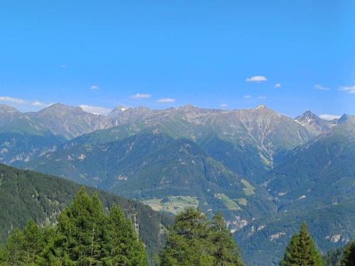 a view of a mountain range with trees in the foreground at Glücksmoment in Kaunerberg