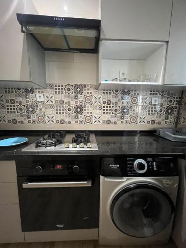 a kitchen with a stove and a washing machine at Résidence Luna in Oran