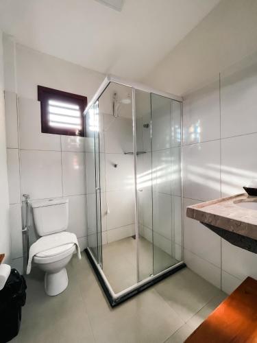 a bathroom with a glass shower and a toilet at Villa do Sol - Icaraí de Amontada in Icaraí