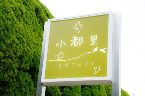 a sign for a kotoren in front of a bush at Arima Hot Spring Ryokan Kotori in Kobe