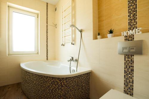 a bathroom with a tub and a window at Dom na Folwarku POKOJE I APARTAMENTY, BEZPŁATNY ZAMYKANY PARKING NA TERENIE POSESJI in Kielce