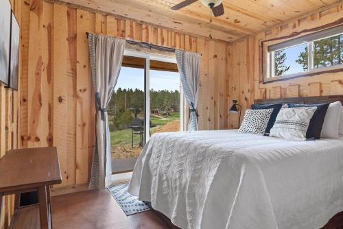 a bedroom with a bed and a large window at Sun Filled Joy BHBungalows #8 in Custer