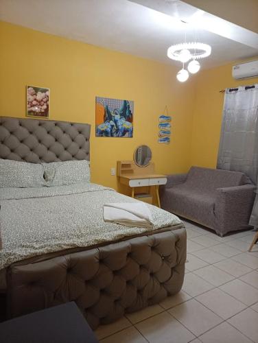 a bedroom with a large bed and a couch at Hotel Mango in Boca Chica