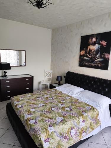 a bedroom with a bed and a painting on the wall at La Casetta di Mari in Legnano