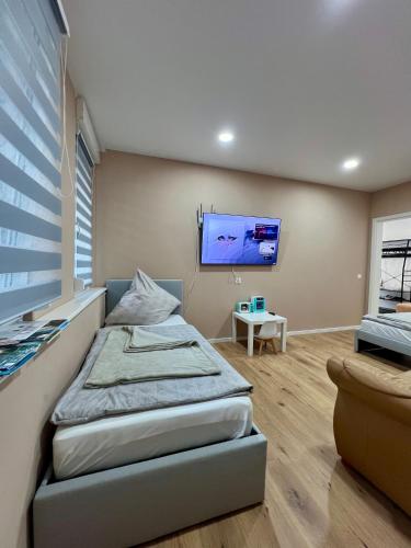 a bedroom with a bed and a flat screen tv at Apartment Marin in Bad Wildbad