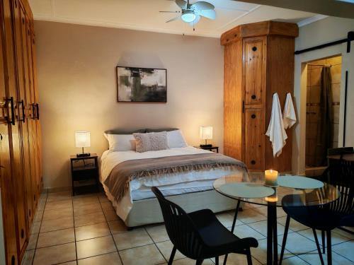 a bedroom with a bed and a table and chairs at The Neighborhood Haven in Richards Bay