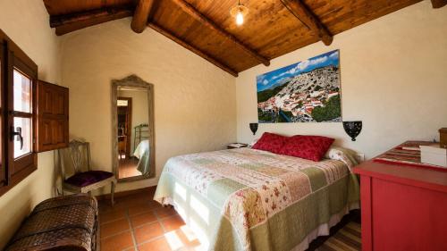 a bedroom with a bed and a painting on the wall at Casa Nazari in Benaocaz