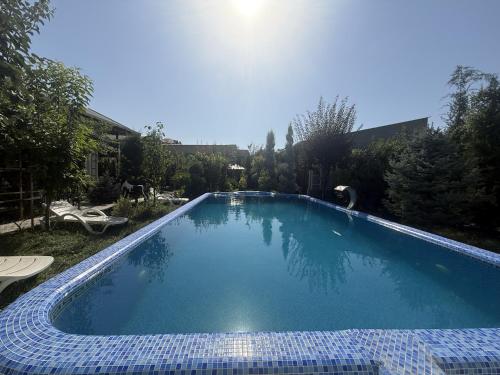 a large blue swimming pool in a yard at Dacha by Bex Sueno in Samarkand