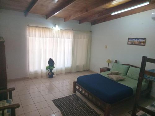 a bedroom with a blue bed and a window at Hospedaje Nely in San Vicente